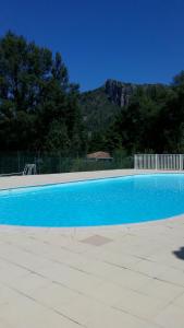 una piscina azul con una montaña en el fondo en T2 Anasa, en Digne-les-Bains