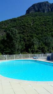 una piscina azul con una valla y una montaña en T2 Anasa, en Digne-les-Bains