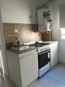 a kitchen with a stove and a counter top at DEPARTAMENTO WITCOMB Con Estacionamiento in Bahía Blanca
