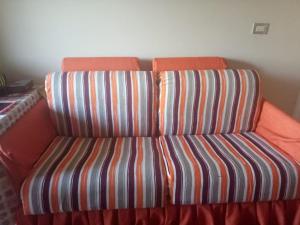 a chair with an orange and striped seat in a room at One Bedroom Chalet at Porto South Beach Families only in Ain Sokhna