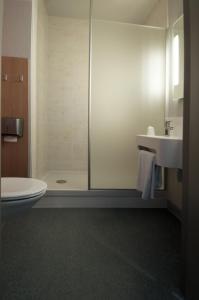 een badkamer met een douche, een toilet en een wastafel bij B&B HOTEL La Rochelle Beaulieu Puilboreau in Puilboreau