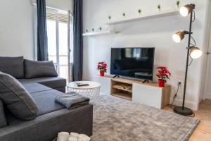 Una sala de estar con un sofá y un televisor. en Moderno-Dinámico, en Vigo