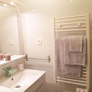y baño con lavabo y ducha con toallas. en VILLA REIALA Chaville, en Chaville