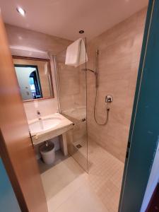 y baño con ducha, lavabo y aseo. en Ferienhotel Alpenhof, en Aurach bei Kitzbuhel