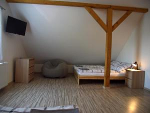 a attic room with a bed and a tv at Baráček–Český ráj in Turnov