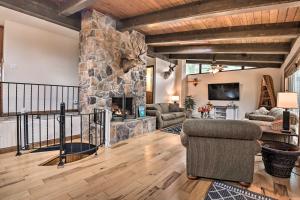 a large living room with a stone fireplace at Indian Lake Retreat with Wet Bar and Covered Deck in Stoystown