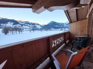 Elle comprend un balcon offrant une vue sur une montagne enneigée. dans l'établissement Ferienhotel Alpenhof, à Aurach bei Kitzbuhel