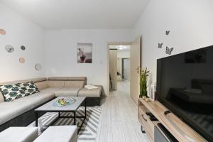 ein Wohnzimmer mit einem Sofa und einem Flachbild-TV in der Unterkunft Apartment DS in Zadar