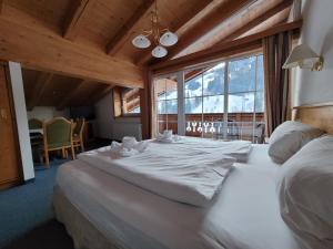 a large white bed in a room with a large window at Ferienhotel Alpenhof in Aurach bei Kitzbuhel