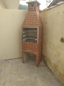 a brick oven sitting next to a brick wall at CASA UBATUBA-MARANDUBA, casa térrea in Ubatuba