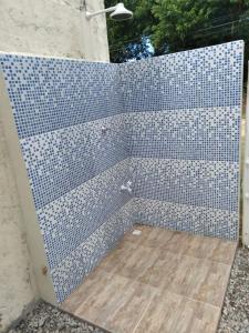 a shower with a blue tiled wall with a wooden floor at CASA UBATUBA-MARANDUBA, casa térrea in Ubatuba