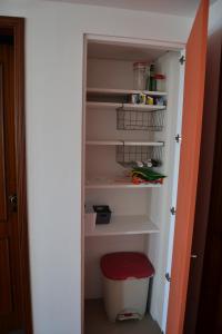 a pantry with a red stool in a closet at Our Sunset Spot in Zambujeira do Mar