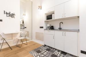 a kitchen with white cabinets and a black and white rug at studio cave in Palma de Mallorca