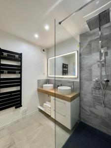 a bathroom with two sinks and a glass shower at FONTAINE ROUGE STREET Marne la Vallée Disneyland Paris Outlet Mode And luxury Village Val d'europe FREE PARKING in Chessy