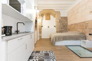 uma cozinha com um lavatório e uma cama num quarto em studio cave em Palma de Maiorca