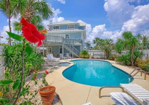 a house with a swimming pool in front of a house at Casa Palmera in Panama City Beach