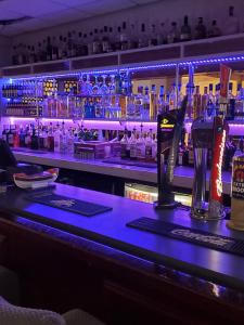 un bar con encimera azul con botellas de alcohol en The Melville Hotel - Central Location en Blackpool