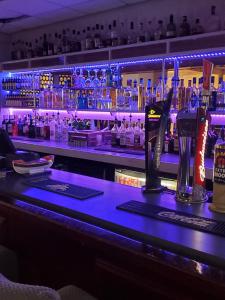 a bar with a blue counter top with bottles of alcohol at The Melville Hotel - Central Location in Blackpool