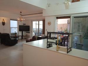 a living room with a kitchen and a living room with a tv at Jaffa sea front, luxury Duplex, Port & Old City 2m walk in Tel Aviv