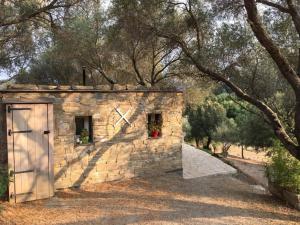 a small stone building with a door and trees at Petite maison en pierre in Saint-Florent