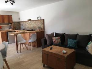 un soggiorno con divano nero e una cucina di Petite maison en pierre a Saint-Florent