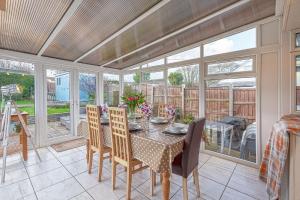 a screened in porch with a table and chairs at Swn Y Don in Llanbedrog