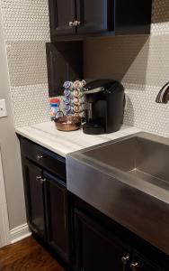 a kitchen counter with a coffee maker and a sink at Modern style and comfort near UC in Cincinnati