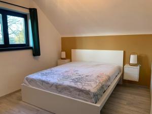 een slaapkamer met een bed en twee nachtkastjes bij Gites douillets à l’orée des bois. in Houyet