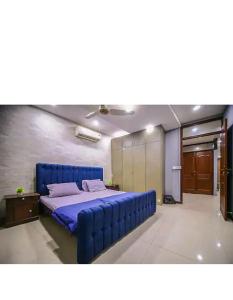 a bedroom with a blue bed in a room at Private 2BD Apartment Opposite Dha Phase 8 in Lahore