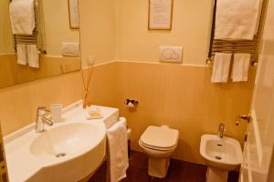 ein Badezimmer mit einem weißen Waschbecken und einem WC in der Unterkunft Caput Mundi Suite in Rom