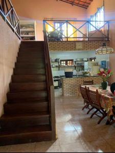 a staircase in a room with a table and a kitchen at Sítio São Gerardo - Aconchegante casa no campo. in Guaramiranga