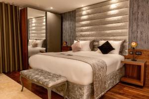 a bedroom with a large white bed and a bench at The Village Boutique and SPA in Naxxar