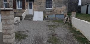 uma entrada em frente a uma casa com um frigorífico branco em John & Ghislaine em Donjeux