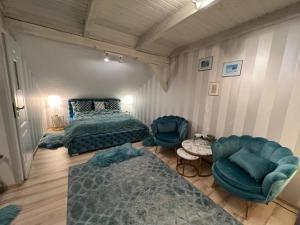 a bedroom with a bed and a couch and chairs at Comfort Zone Ostróda BLUE in Grabinek