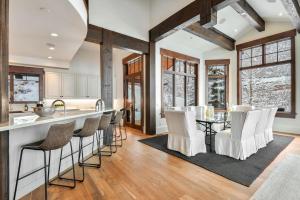 a kitchen with a bar with white chairs at Deer Hollow Chalet in Park City