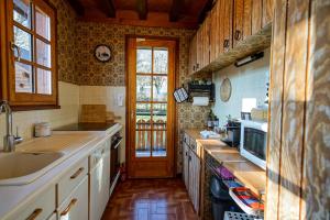 cocina con armarios de madera, fregadero y puerta en Le Chalet Soleil, en Lathuile