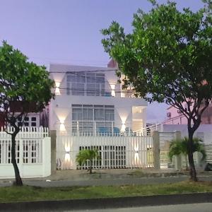 una casa blanca con una valla blanca en Bahia San Andres Hospedaje en San Andrés