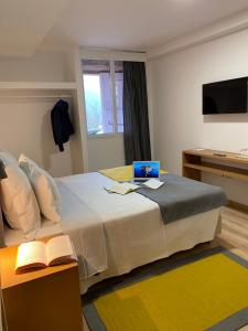 1 dormitorio con 1 cama con ordenador portátil en Casa de São Marcos, en Manteigas