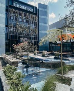 a building with tables and chairs in front of it at Nindya Biodistrict Hotel Bandung in Bandung