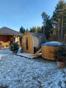a yurt with a hot tub next to a house at Domki nad jeziorem czorsztyńskim in Dębno
