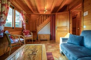 a living room with a couch and a table at Le Chalet Bonheur in Lathuile