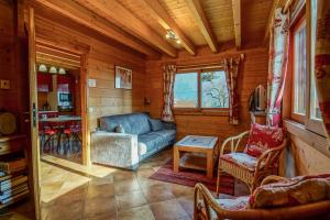 a living room with a couch and a table at Le Chalet Bonheur in Lathuile