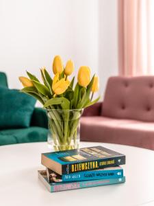 un jarrón de libros sobre una mesa con flores en Apartament pod lasem, en Ołdrzychowice Kłodzkie