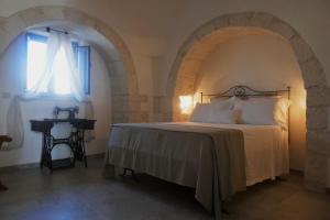 a bedroom with a bed and a window at Trullo La chicca della valle in Cisternino +41 photos
