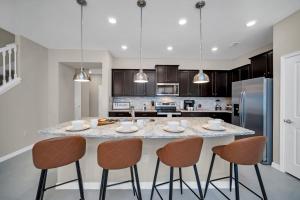 a kitchen with a large island with bar stools at Free Waterpark Private Splash Pool Near Disney in Davenport