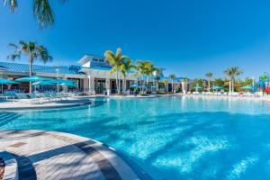 a large swimming pool with palm trees and umbrellas at Free Waterpark Private Splash Pool Near Disney in Davenport
