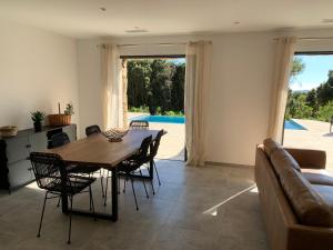 a dining room with a table and chairs and a couch at DOMAINE NAPOLEON CORSICA FIGARI in Figari