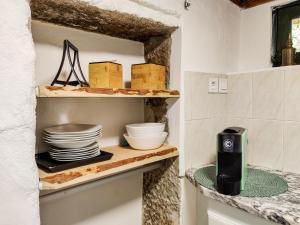 una cocina con una estantería con platos y una cámara. en Neiva River House - Azenha Next to the River en Esposende