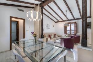 a dining room with a glass table and chairs at BnS Dauro Suites in Granada