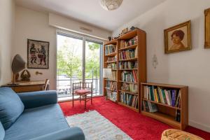 a living room with a blue couch and book shelves at Port Royal Apart de Charme-Parking-Cœur de Ville in Nantes